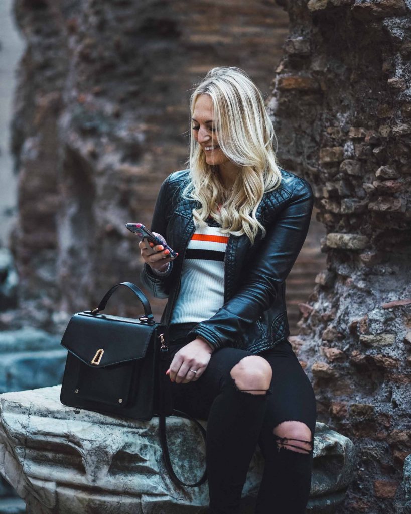 Blonde blogger checking her phone workin on Instagram