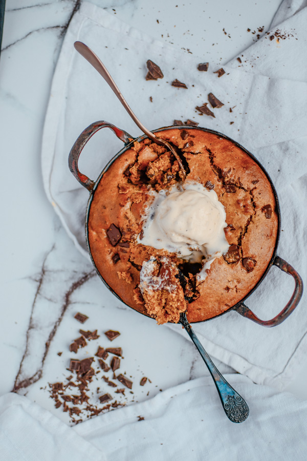 Chocolate chip cookie skillet with ice cream and two spoons